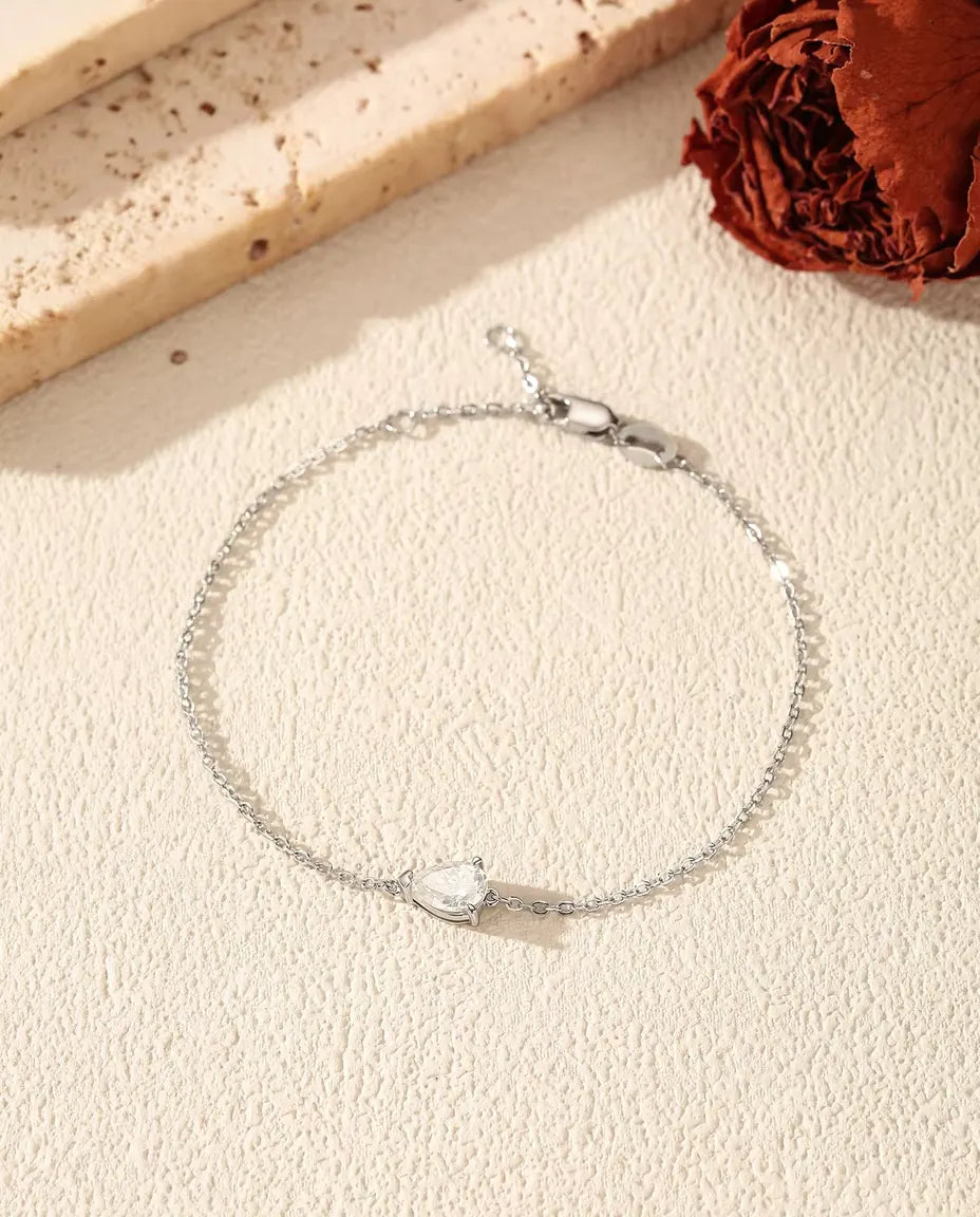 Fint sølvarmbånd med en dråbeslebet moissanite på 5 x 7 mm holdt af tre klør i 925 sterling sølv.