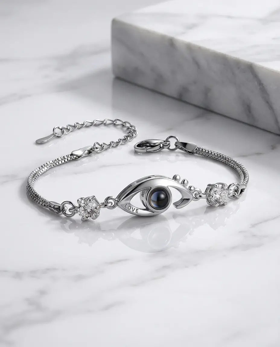 Armbånd med et beskytterøje i zirkon, der rummer et mikroindgraveret billede, og ordet LOVE på siden.