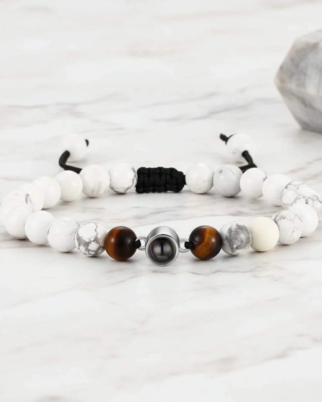 Armbånd af hvide magnesitperler med naturlige årer og en midtersten, der rummer et personligt billede.