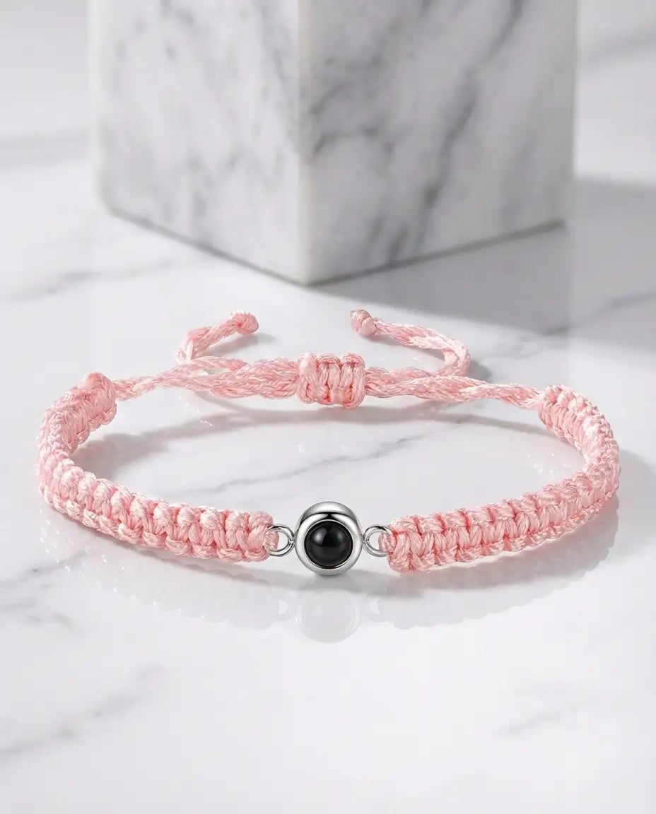Armbånd af flettet snor med en rund perle i midten, der rummer et personligt billede indeni.