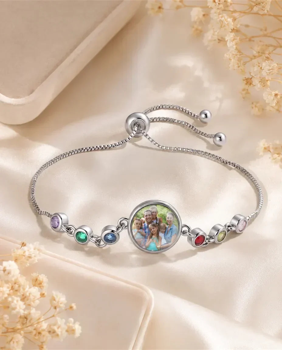 Armbånd med en rund glasperle med personligt billede omgivet af små fattede fødselssten i zirkonia.