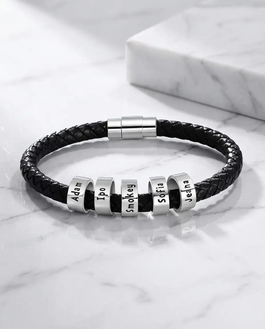 Armbånd til mænd i flettet snor med polerede perler, der hver bærer et dybt indgraveret navn.