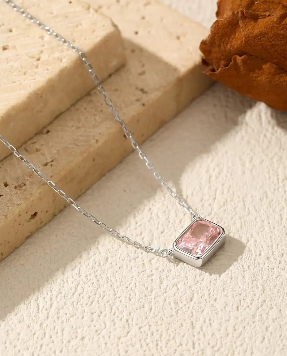 Lille lyserød zirkonia på 5 x 7 mm i en glat lukket ramme af 925 sterling sølv på en fin ankerkæde.