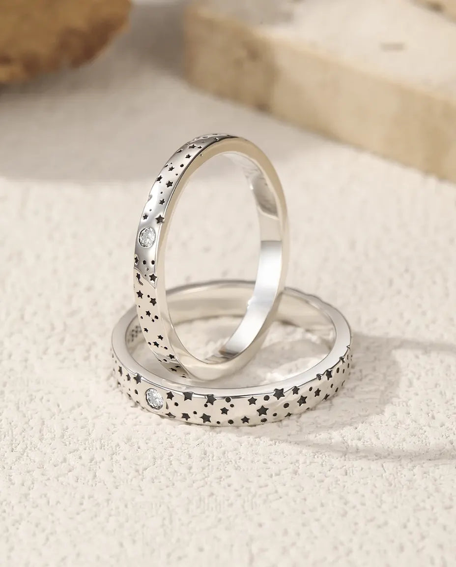 Sæt med to matchende sølvringe med stjernemotiv i moissanite, en smal og en bred, i 925 sterling sølv.