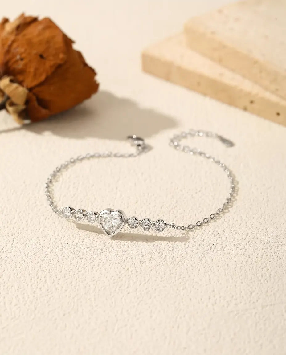 Fint armbånd i 925 sterling sølv med et hjerteslebet moissanite i lukket fatning på en tynd ankerkæde.