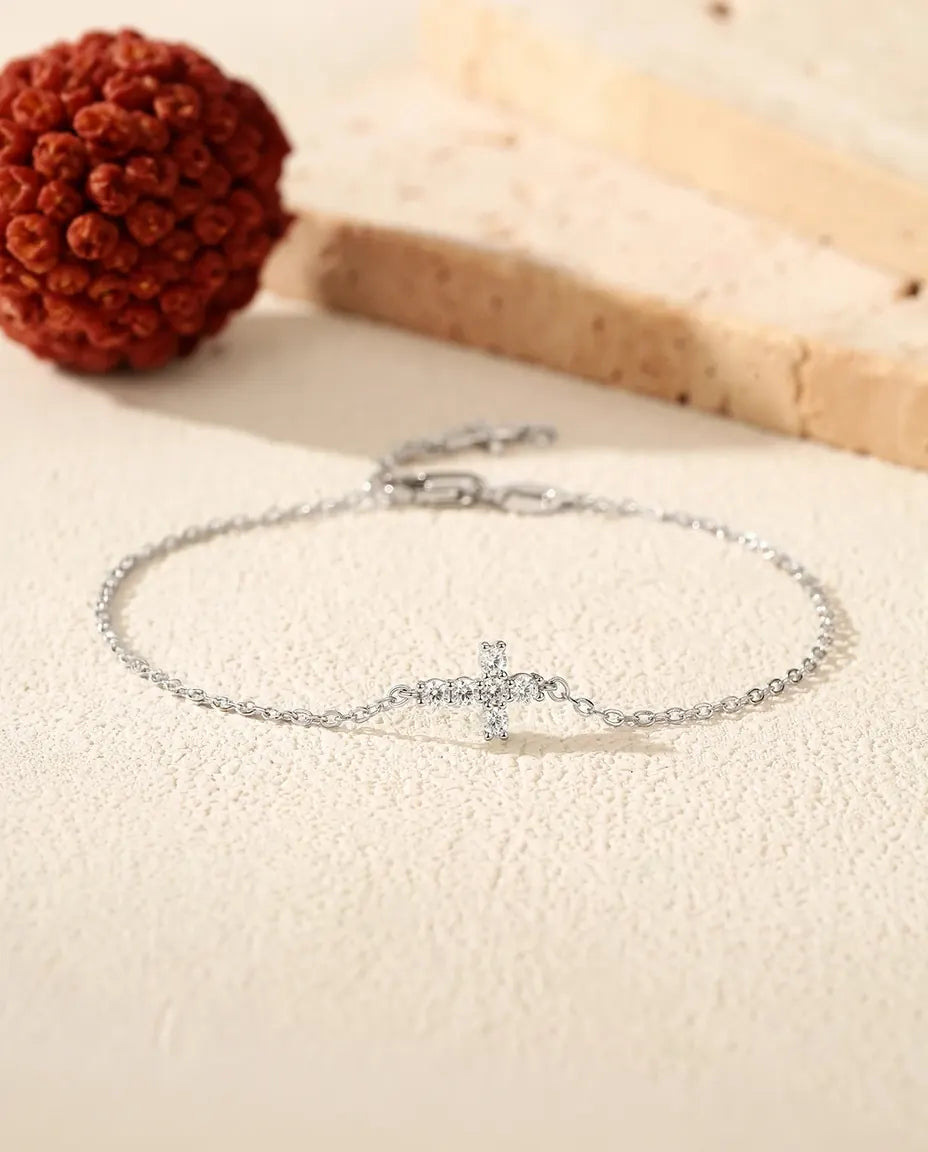 Fint sølvarmbånd med et lille korscharm sat med en klar moissanite i 925 sterling sølv.
