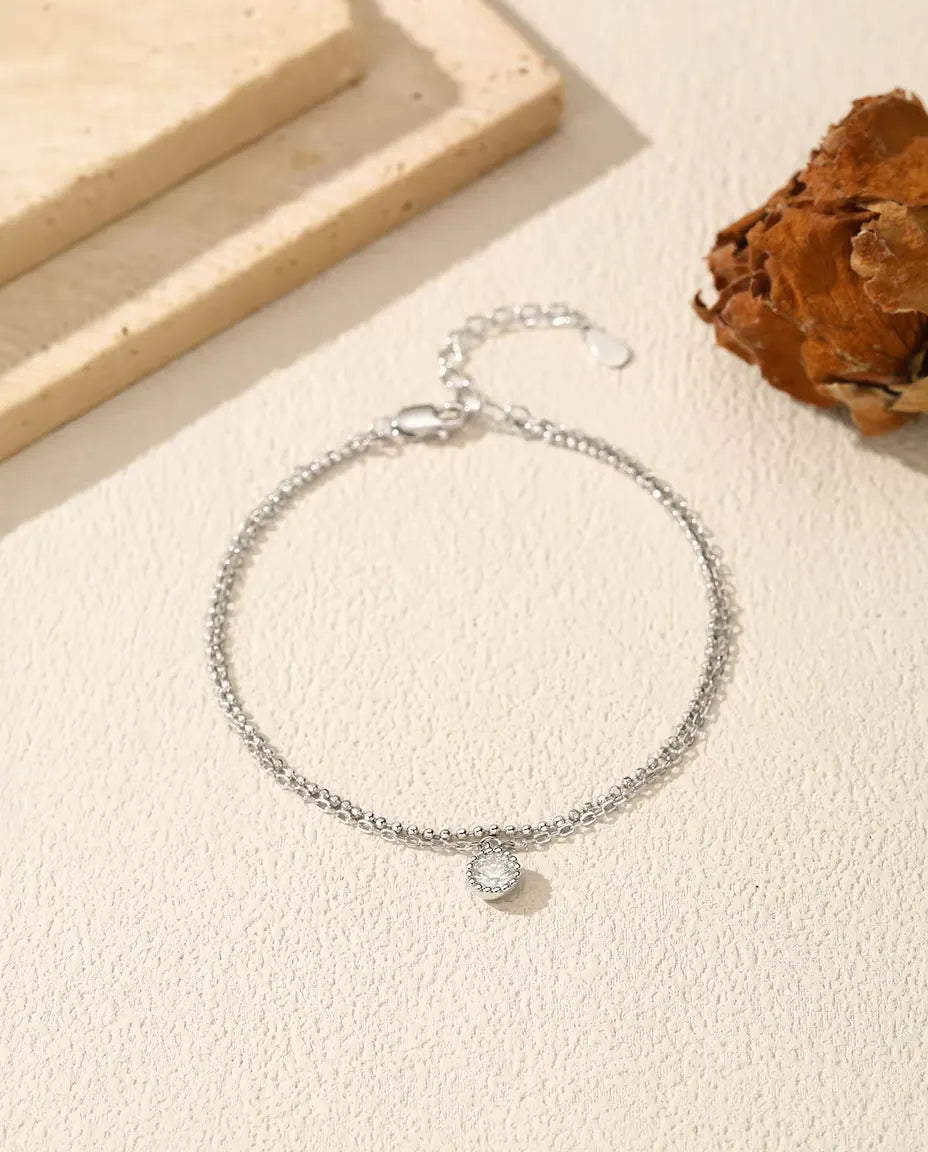 Sølvarmbånd med to fine kæder og en rund moissanite på 0,50 ct i lukket fatning i 925 sterling sølv.