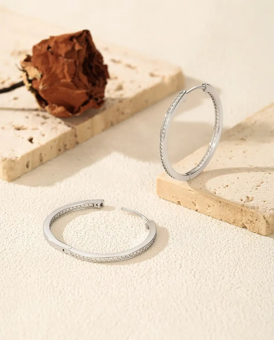 Store creoler i 925 sterling sølv med blank yderside og en tæt række klare sten fattet på indersiden.
