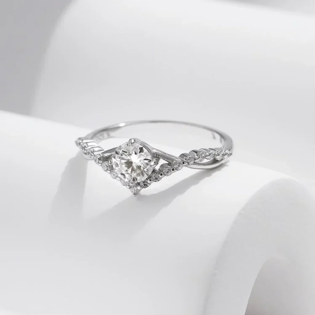Sølvring med farveløs moissanite på 0,50 ct i klofatning og små accentsten langs skinnen i 925 sølv.