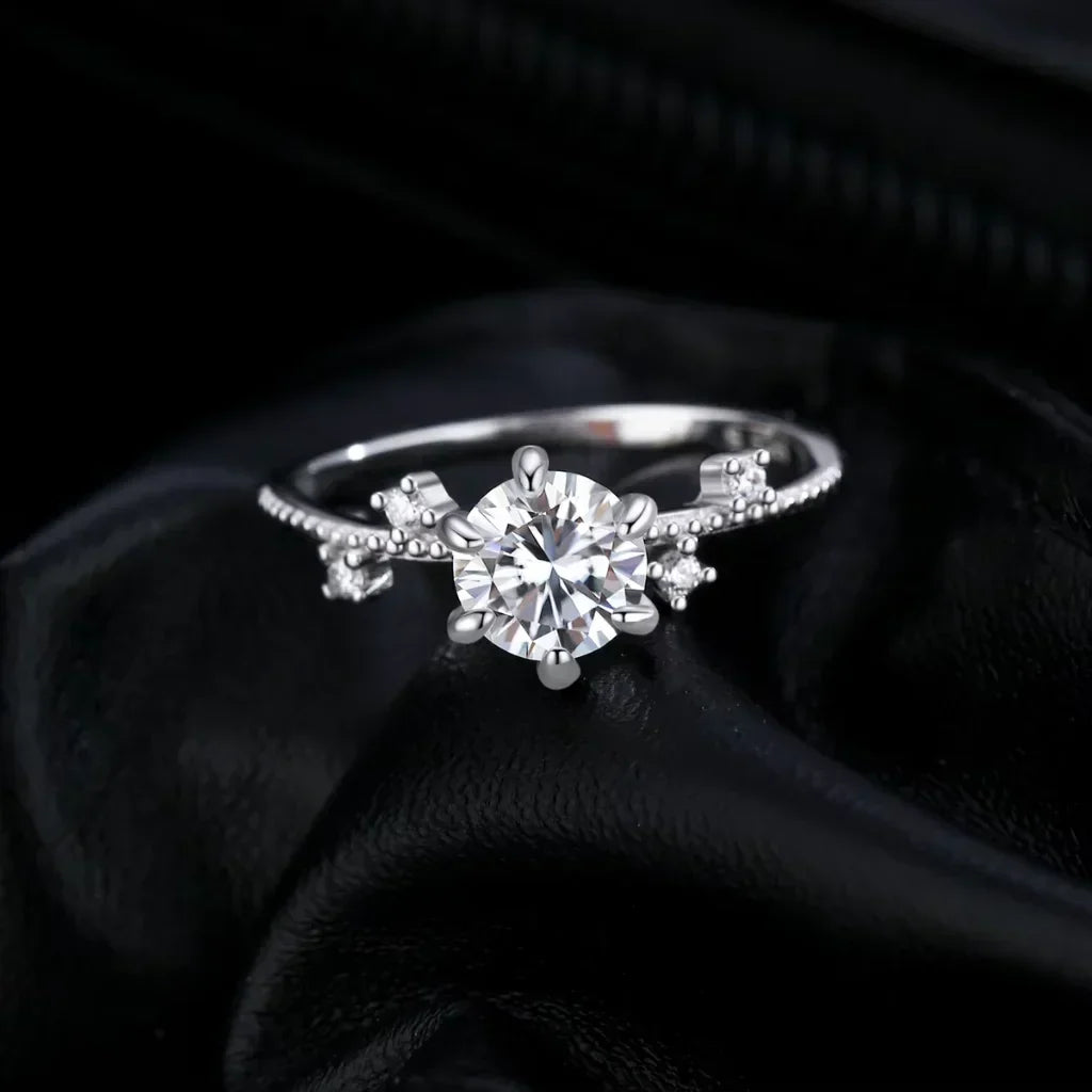 Sølvring med rund moissanite på 1 karat løftet i en blomsterfatning med seks tynde klør, 925 sterling sølv.