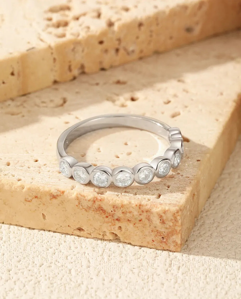 Sølvring med ni runde moissanitter i hver sin lukkede, polerede fatning hele vejen rundt, 925 sterling sølv.