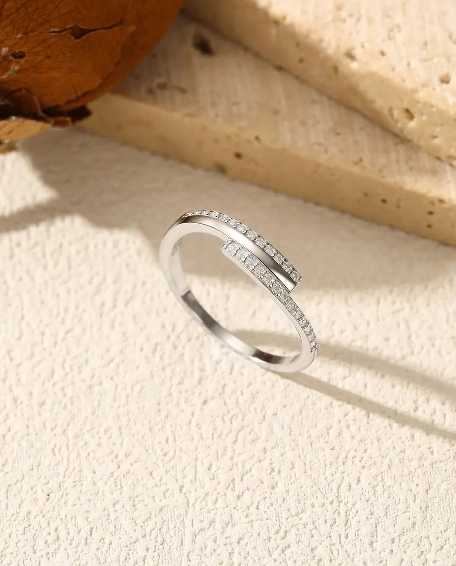 Sølvring med to krydsende pavélinjer af 26 små moissanite-sten og polerede barrer, 925 sterling sølv.