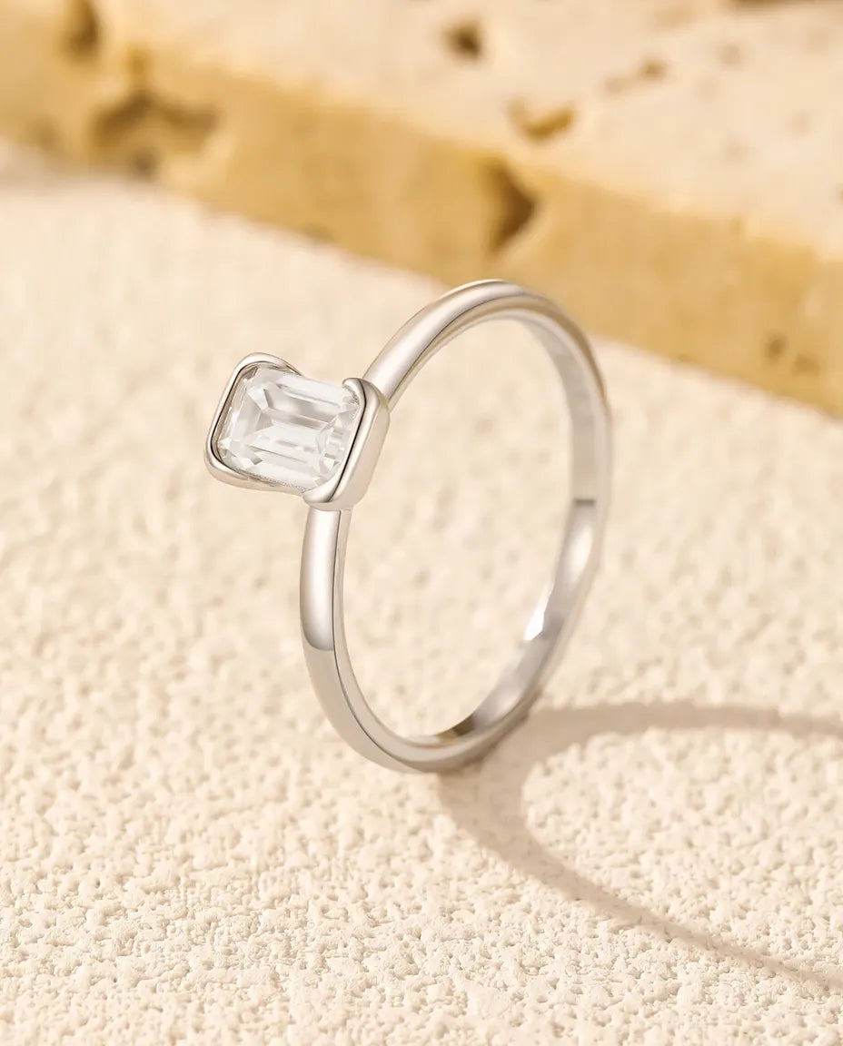 Sølvring med rektangulær smaragdslebet moissanite sat i klør på en fin skinne i 925 sterling sølv.