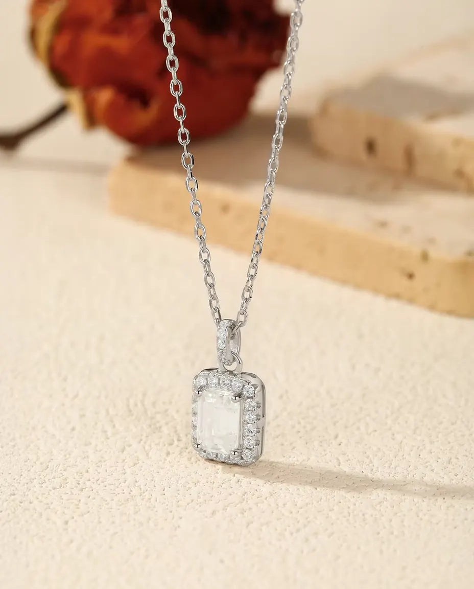 Halskæde i 925 sterling sølv med et rektangulært vedhæng: en moissanite i emerald cut i en halo af små zirkonia.