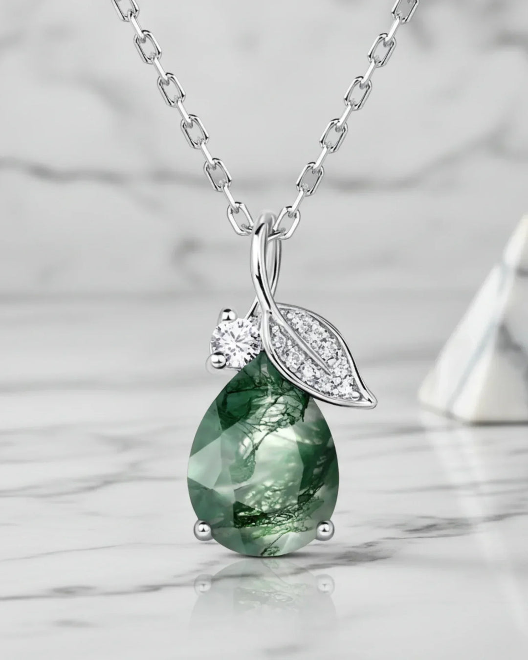 Dråbeslebet grøn moss agate med et lille sølvblad og en zirkon i et vedhæng af 925 sterling sølv.