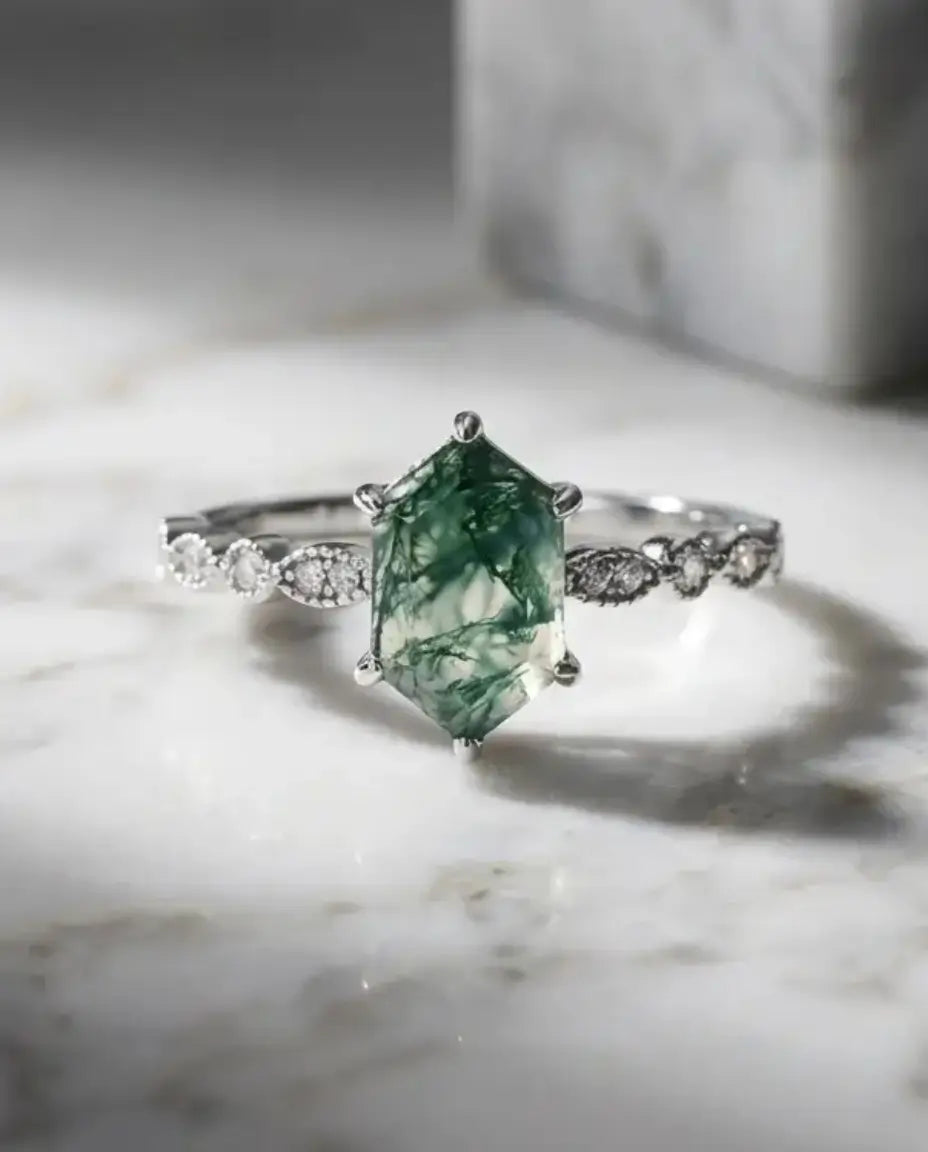 Sølvring med aflang hexagonslebet grøn moss agate i seks klofatninger på en Art Deco-skinne i 925 sølv.