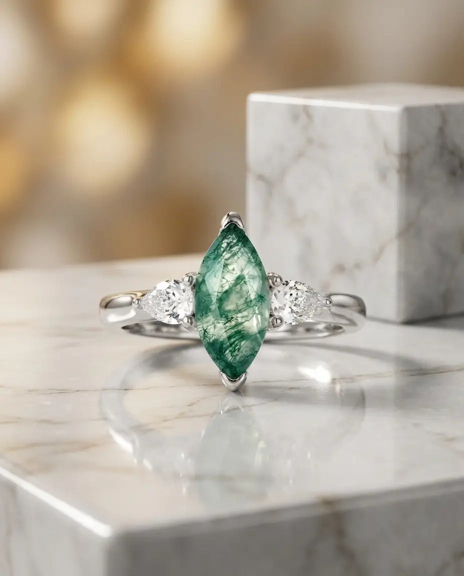 Hvidguldbelagt sølvring med marquiseslebet grøn moss agate mellem to pæreslebne zirkoner i 925 sterling sølv.