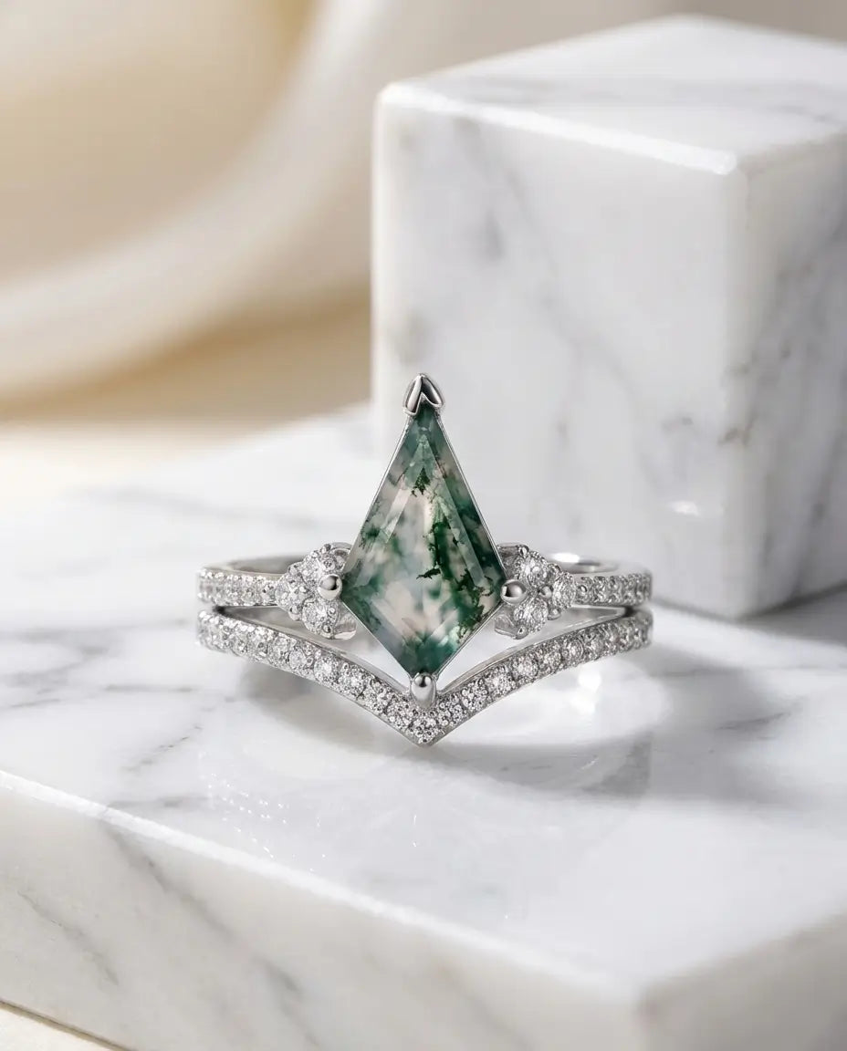 Ringsæt med kite-slebet moss agate på 7x11 mm, zirkoniasten omkring stenen og en V-formet chevronring i sølv.
