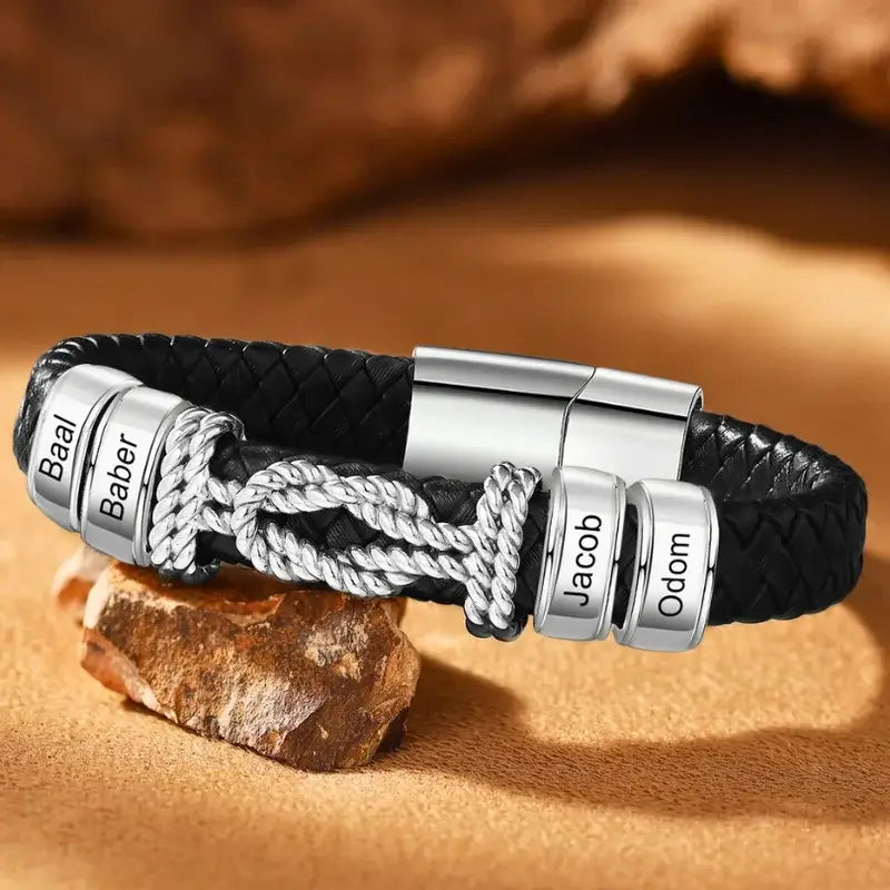 Sort læderarmbånd til mænd med en bred poleret plade i rustfrit stål med et indgraveret navn.