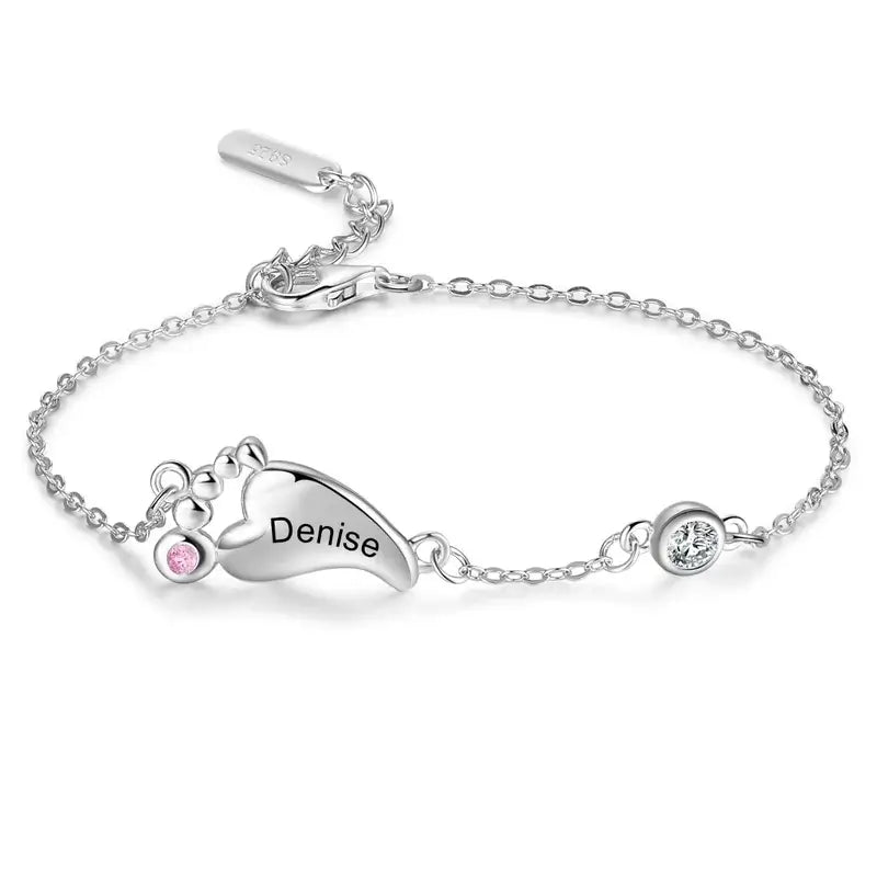 Armbånd i 925 sterling sølv med en charm formet som små babyfødder, indgraverede navne og fødselssten.