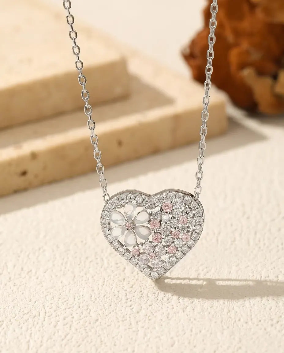 Hjertevedhæng i 925 sterling sølv med en blomst af perlemor og lyserøde og klare zirkoner.