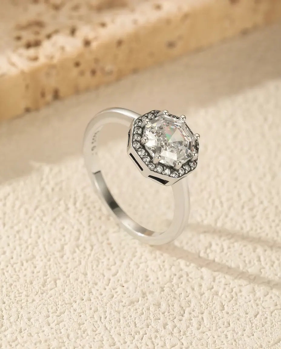 Sølvring med ottekantet halo omkring en trappeslebet klar zirkonia på 7 mm i 925 sterling sølv.