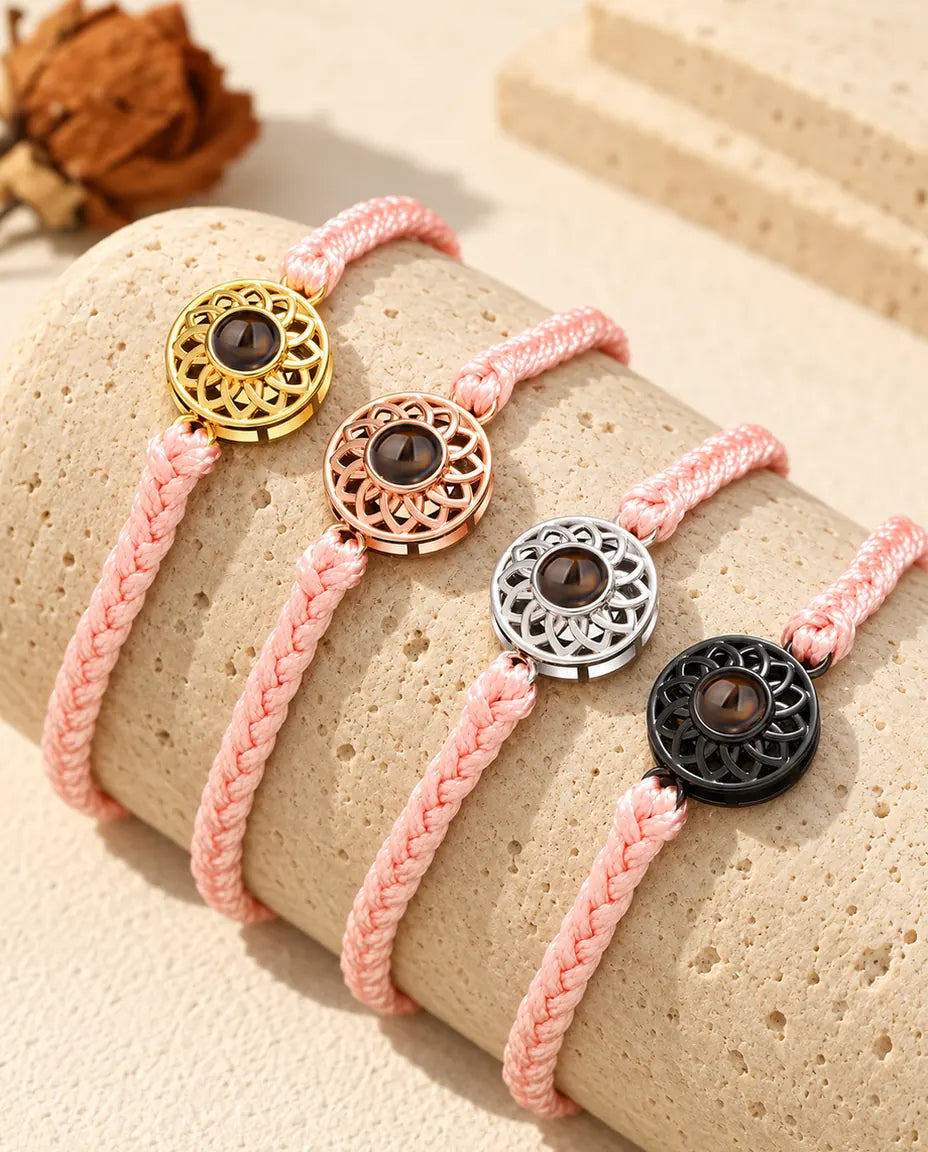 Tynde lyserøde flettede armbånd med billede indeni og runde charms i guldfarvet, rosaguldfarvet, sølvfarvet og sort