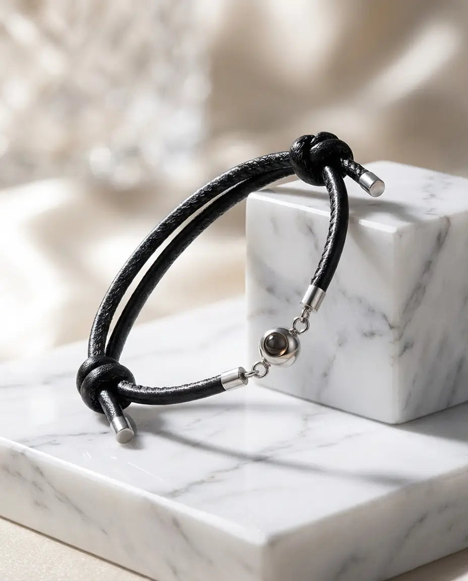 Armbånd af flettet læder med en perle i rustfrit stål, der rummer et personligt billede indeni.