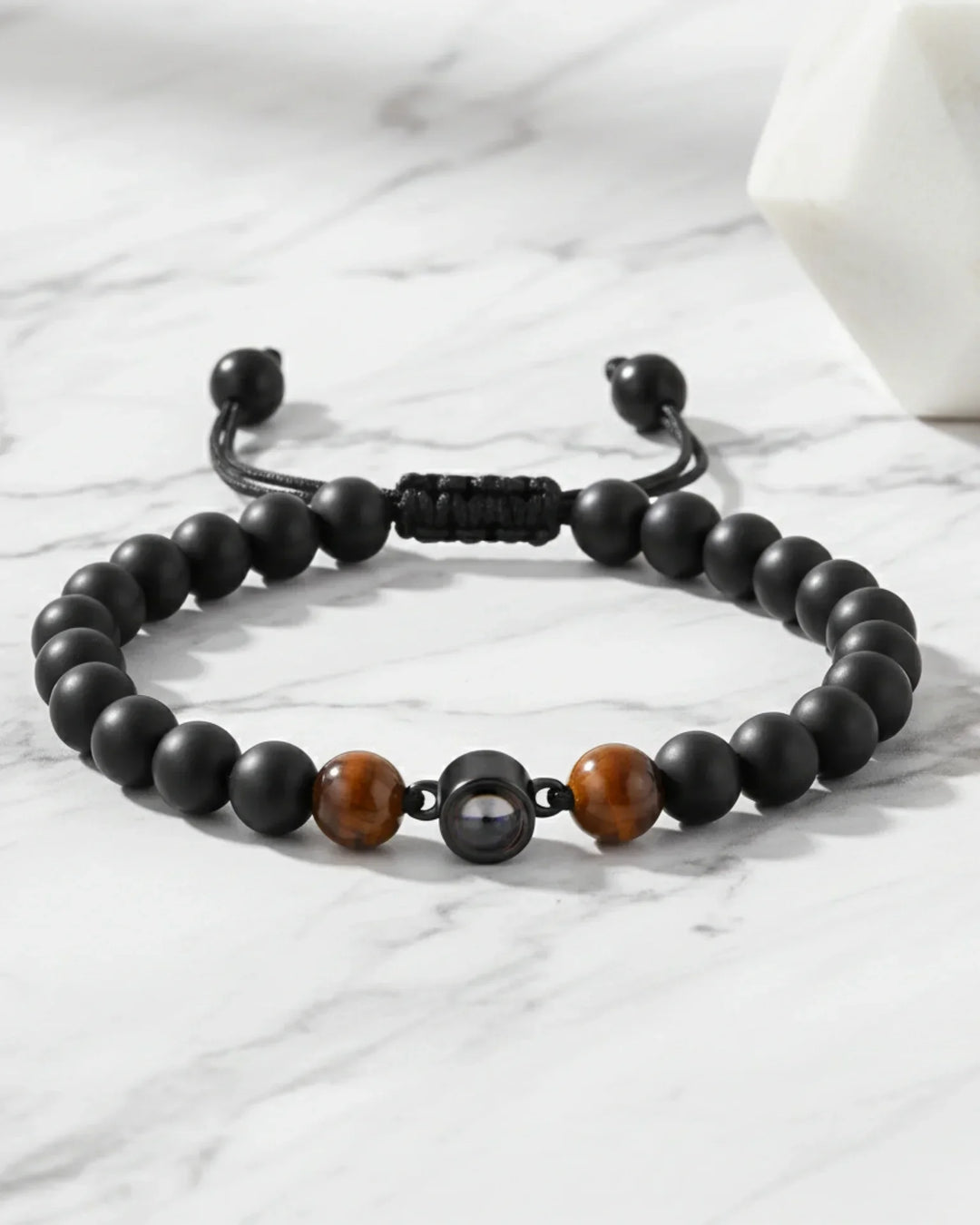 Armbånd til mænd af mørke, naturlige lavasten med en perle i midten, der rummer et skjult billede.