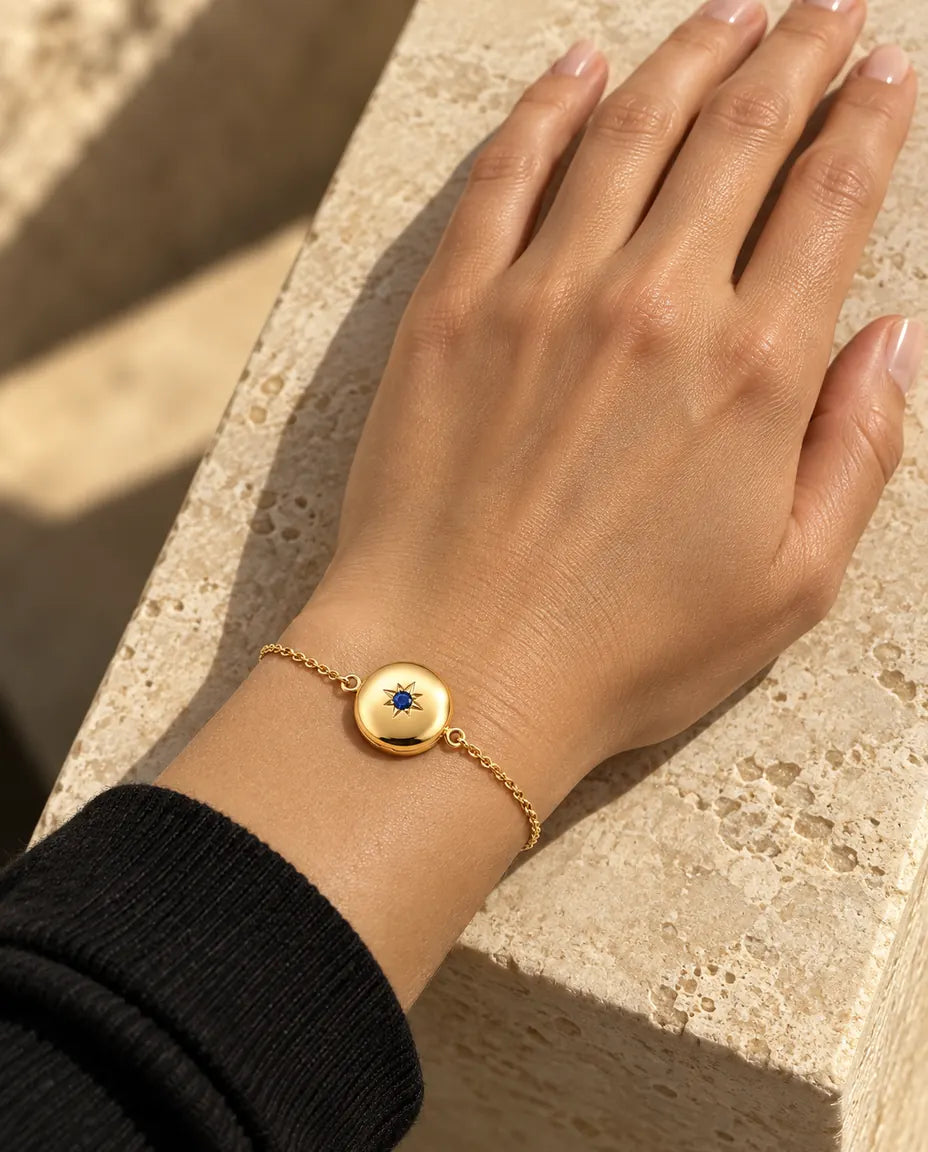 Nærbillede af armbåndet med rund medaljon om håndleddet