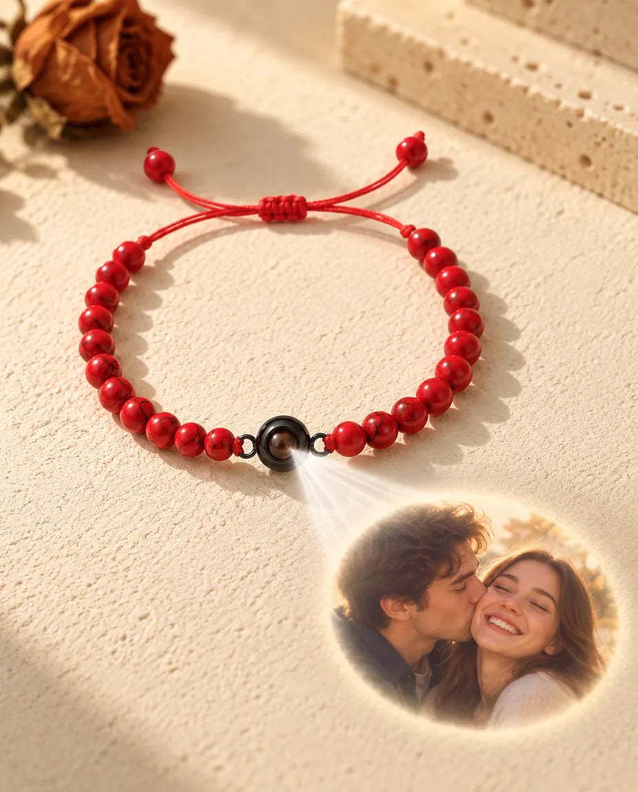 Lys gennem den brune sten i armbåndet med røde perler kaster et billede af et smilende par frem