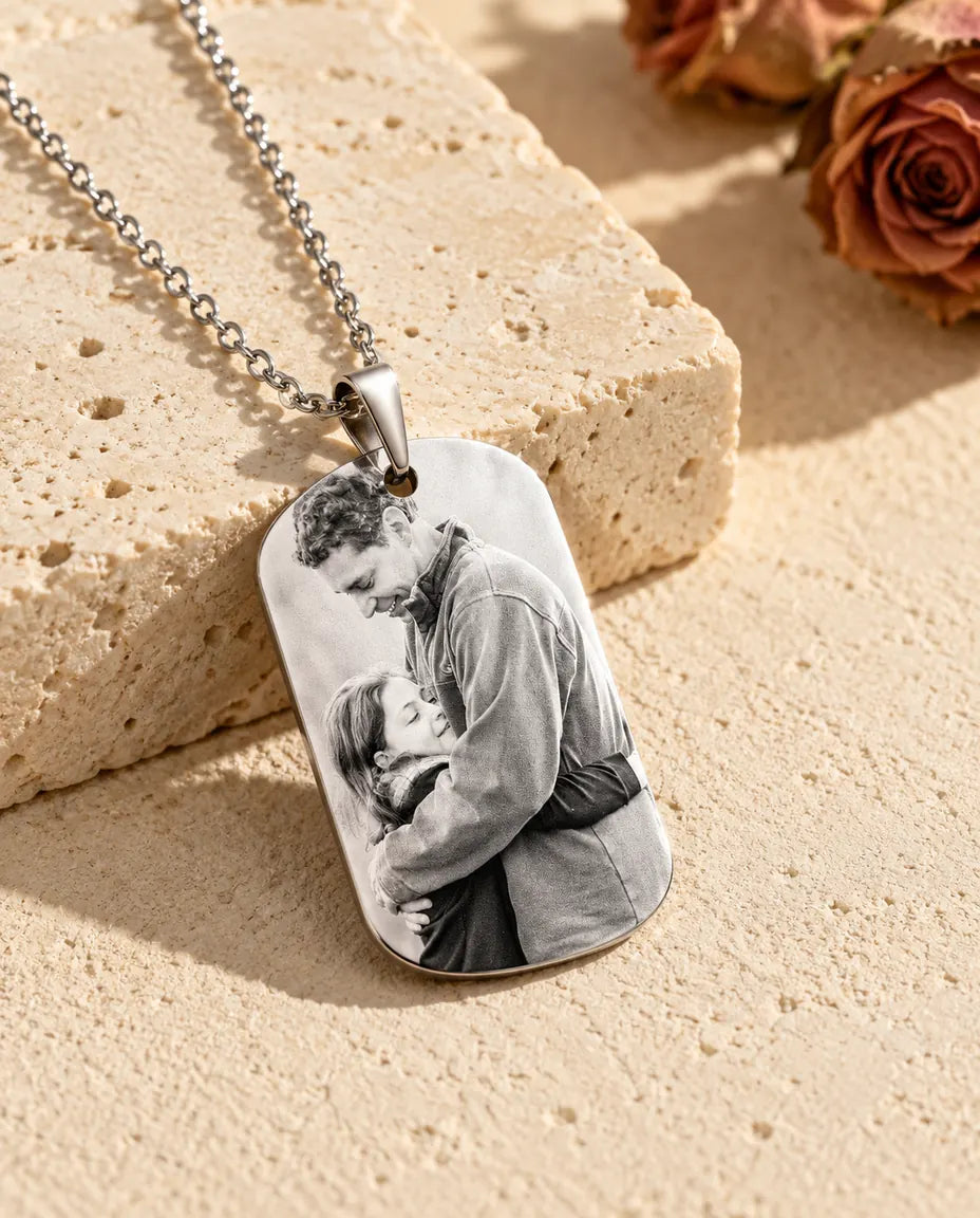 Dog tag med indgraveret sort-hvidt billede mod en stenblok