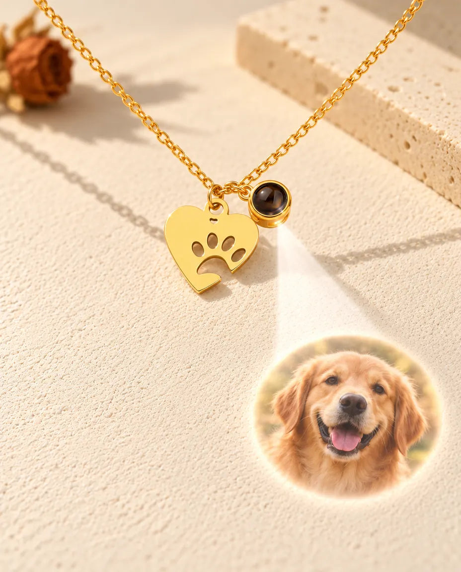 Lys gennem den lille brune sten på den guldfarvede halskæde med pote viser et billede af en golden retriever