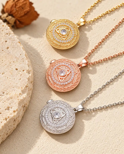 Medaljoner med triquetra i guldfarvet, rosaguldfarvet og sølvfarvet stablet ved en travertinplade