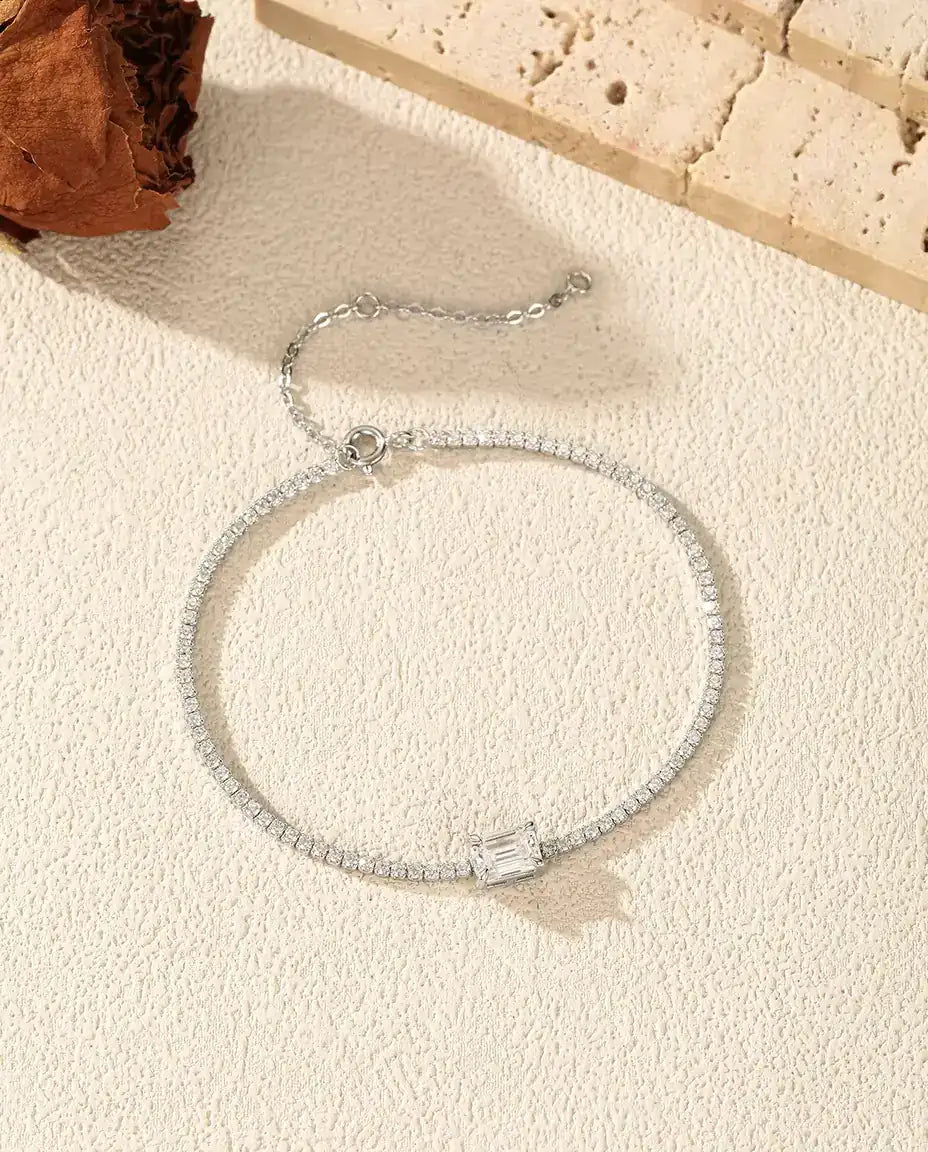 Tennisarmbånd i 925 sterling sølv med zirkonia hele vejen rundt og en emeraldslebet moissanite på tværs.