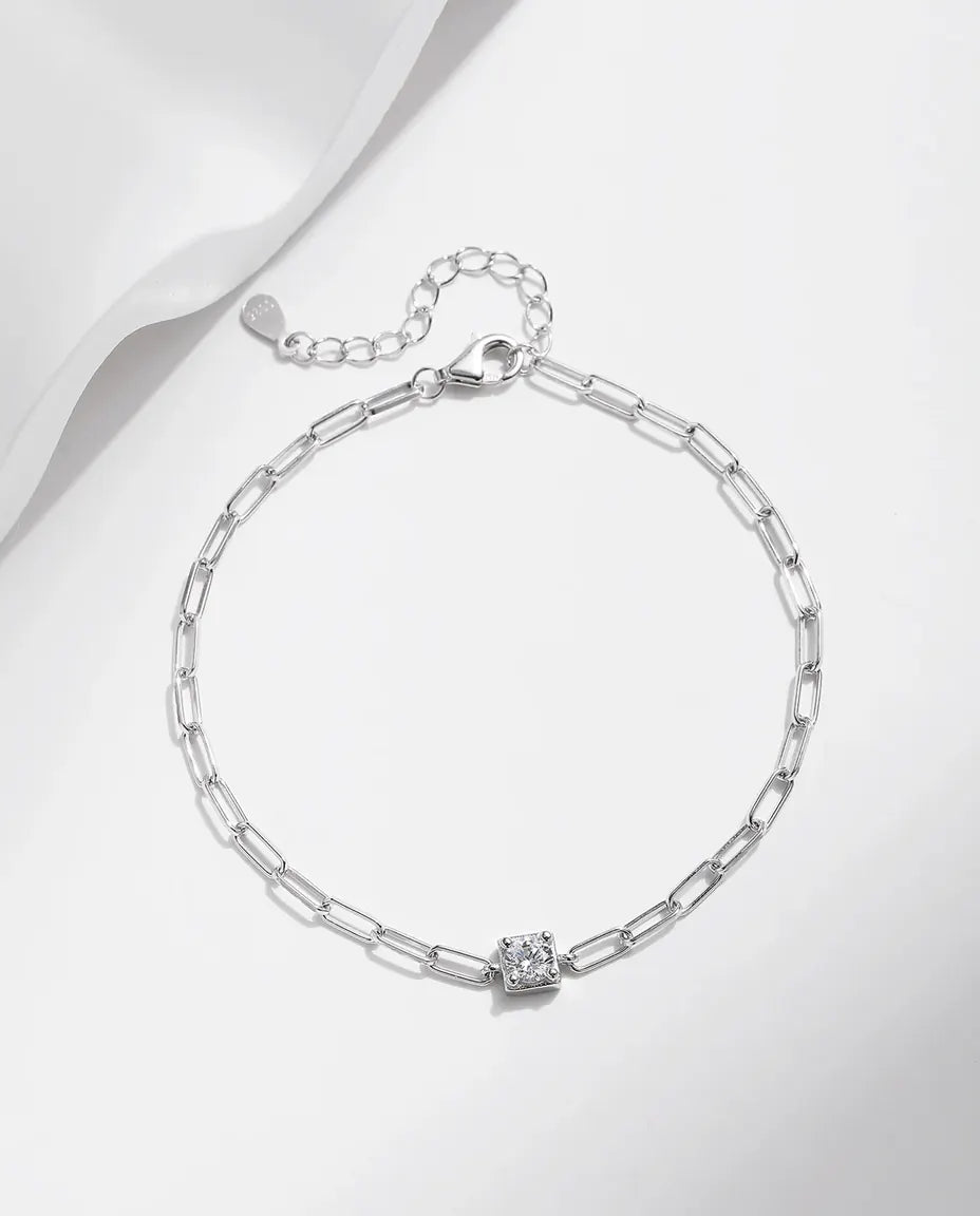 Sølvarmbånd med en moissanite i firkantet lukket fatning på en kæde med aflange led i 925 sterling sølv.