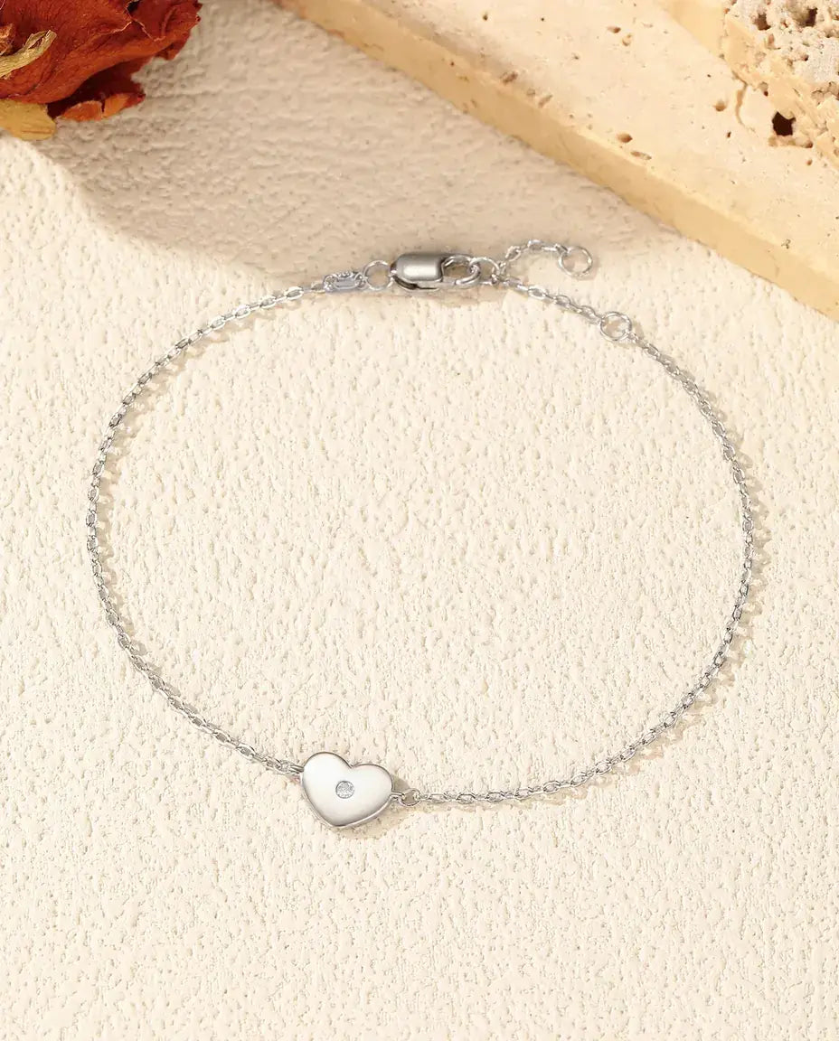 Fint sølvarmbånd med et lille hjertecharm sat med en klar moissanite i 925 sterling sølv.