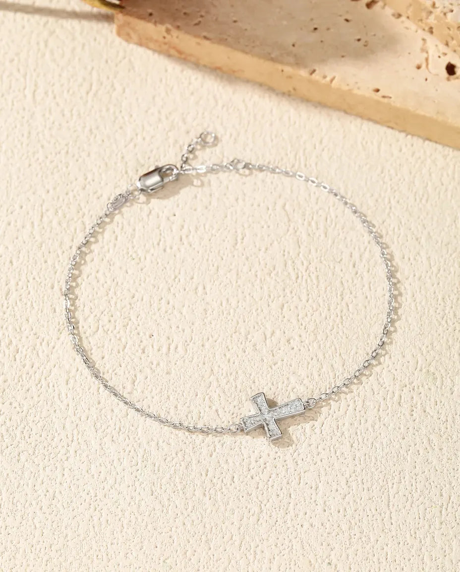 Armbånd i 925 sterling sølv med et lille kors sat helt til med runde moissanite på en fin ledkæde.