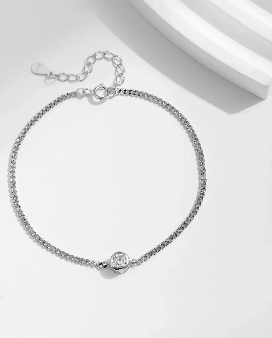 Fint sølvarmbånd med en rund moissanite på 4 mm i lukket fatning på en tynd ankerkæde i 925 sterling sølv.