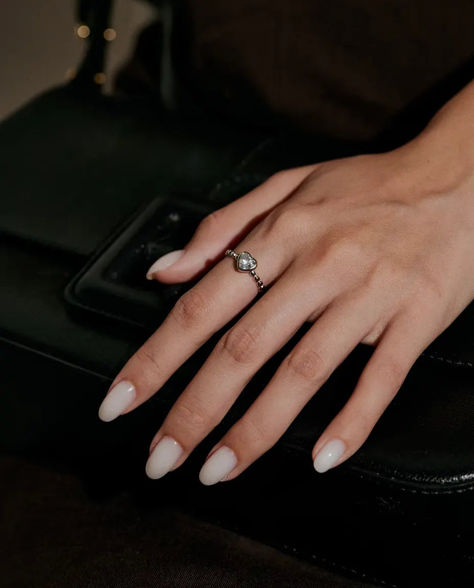 Moissanite Ring i 925 Sølv - båret på en hånd, der hviler på en sort taske