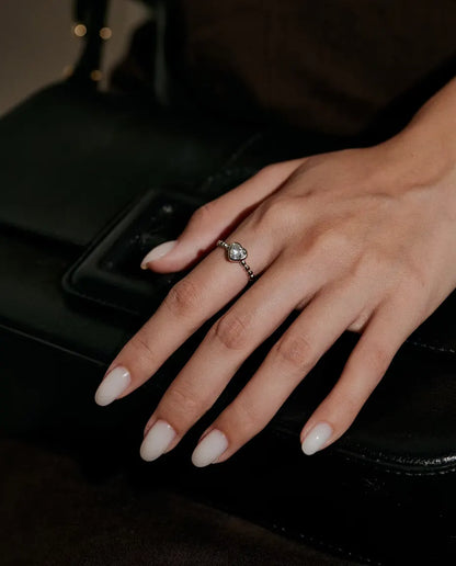 Moissanite Ring i 925 Sølv - båret på en hånd, der hviler på en sort taske