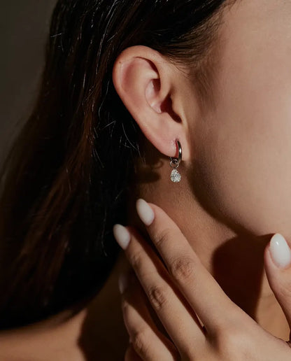 Moissanite Øreringe i 925 Sølv - båret i en models øre, hånden tæt på ansigtet