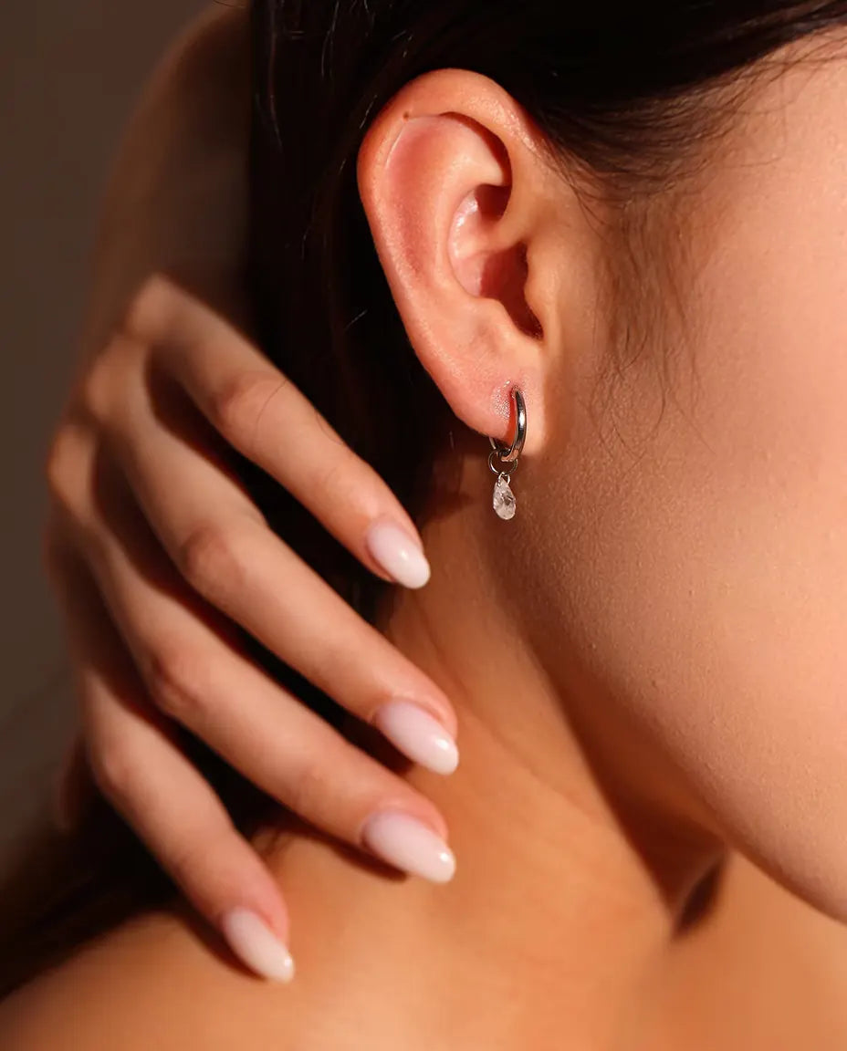 Moissanite Øreringe i 925 Sølv - båret i en models øre, hånden ved halsen