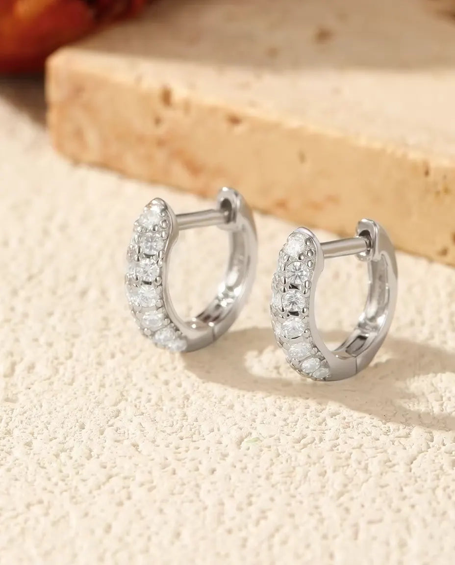 Små creoler i 925 sterling sølv besat på ydersiden med en tæt række klare moissanite i tre størrelser.