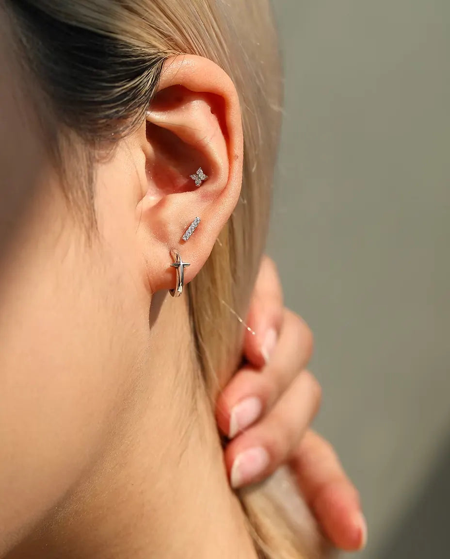 Moissanite Ørestikker i 925 Sølv - båret af en model, der stryger håret om bag øret