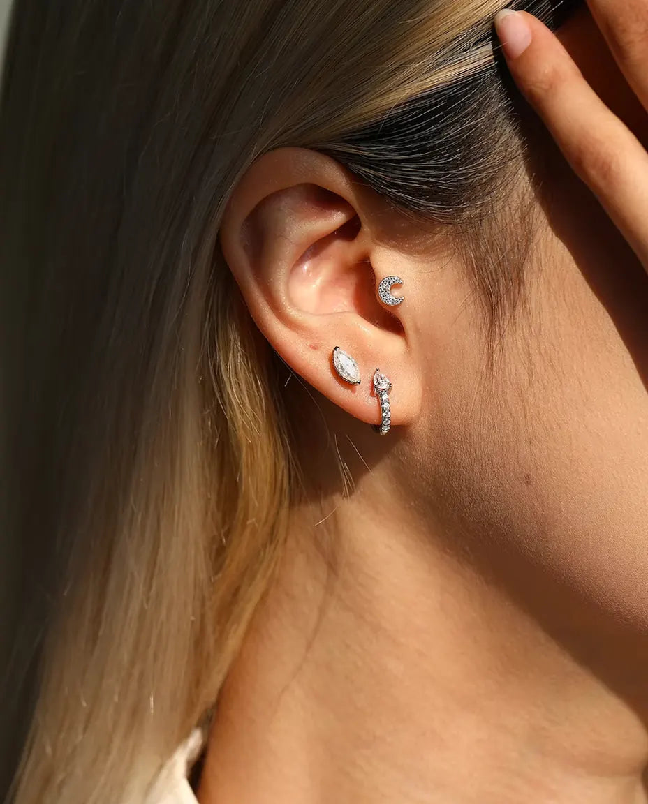 Moissanite Ørestikker - båret af en model, der stryger håret om bag øret