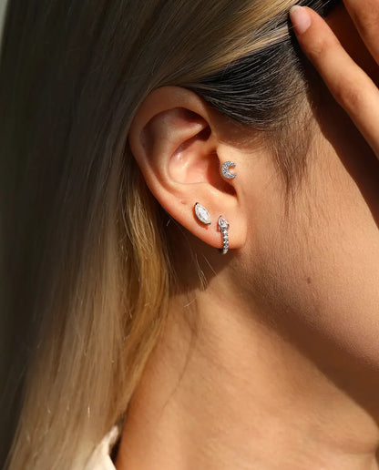 Moissanite Ørestikker - båret af en model, der stryger håret om bag øret