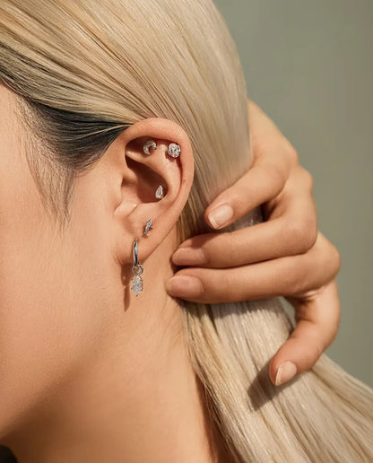 Moissanite Ørestikker i 925 Sølv - båret af en model, der stryger håret om bag øret