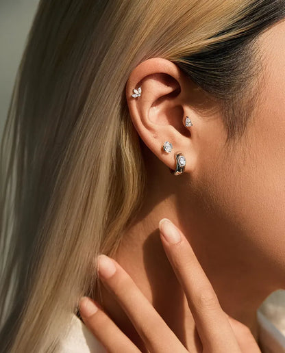 Moissanite Ørestikker i 925 Sølv - båret af en model med hånden ved halsen