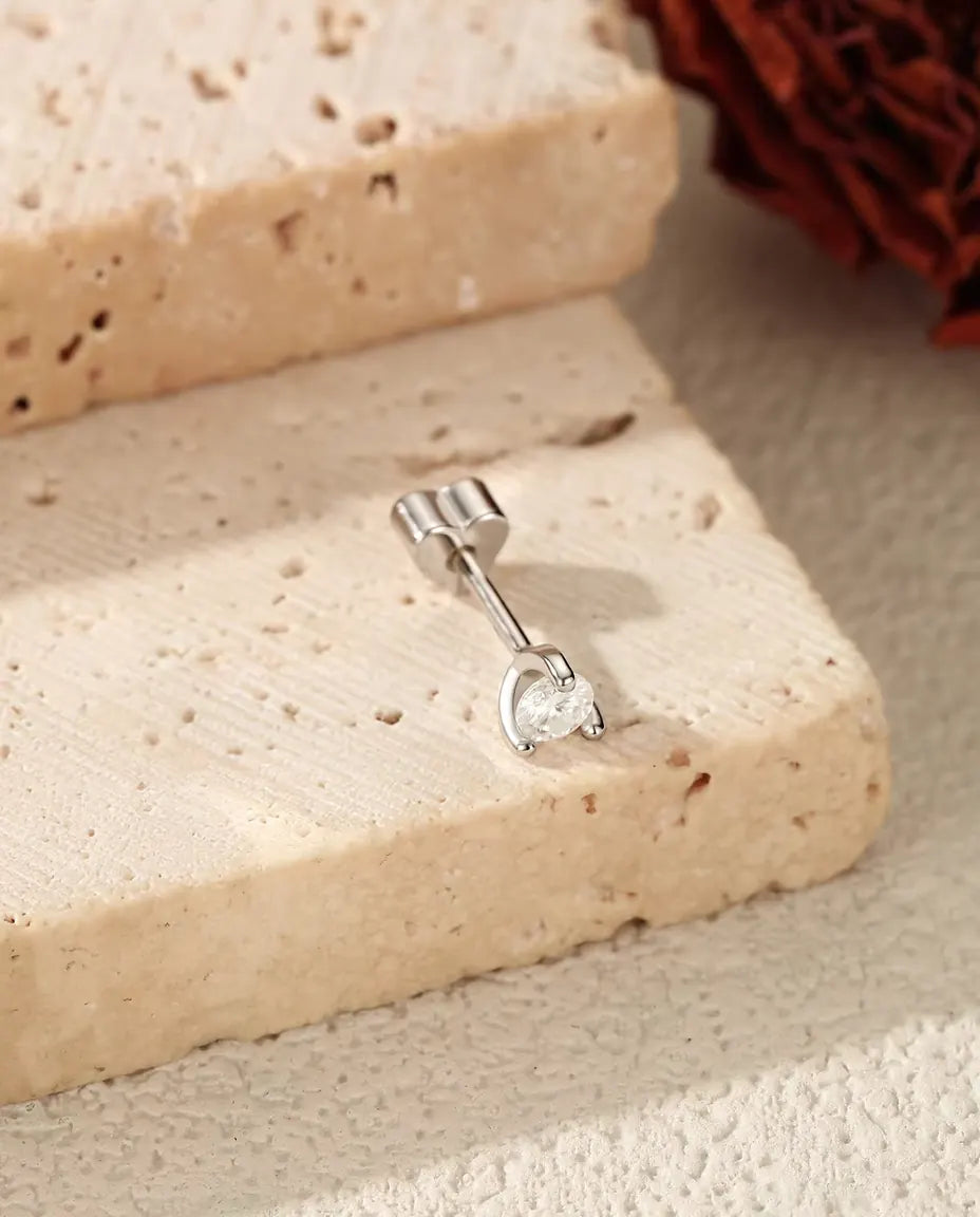 Moissanite Ørestikker i 925 Sølv - liggende på kanten af en travertinplade, låsen sat på
